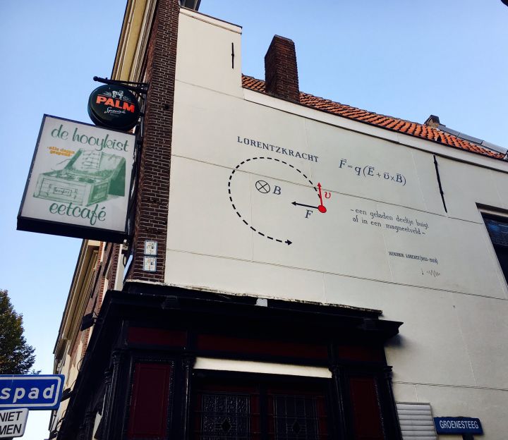 The formula for the Lorentz force on the wall of Eetcafé de Hooykist on the Hooigracht. Hendrik Lorentz lived right across the street from here. The formula describes how a charged particle, for example an electron, is deflected in a magnetic field.
